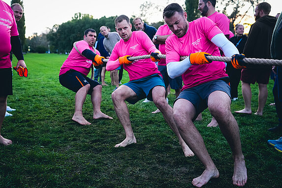 Drei Teilnehmer der Teamchallenge ziehen beim Tauziehen im Sommerhofenpark am Seil