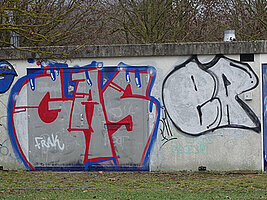 Ein kleines technisches Gebäude ist unschön mit Graffitis beschmiert.