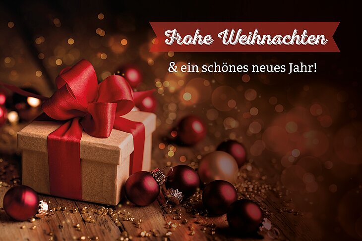 Eine Weihnachtskarte mit einem Geschenk auf der linken Seite und dem Weihnachtsgruß auf der rechten Seite