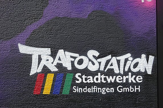 Nahaufname eine Graffitibereiches: Die Worte "Trafostation" und das Logo der Stadtwerke Sindelfingen.