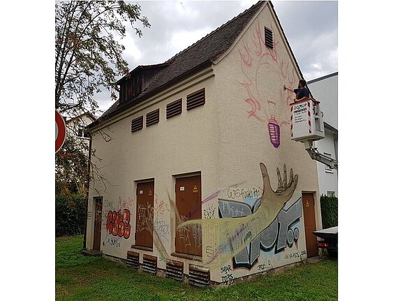 Ein technisches Gebäude ist unschön mit Graffitis beschmiert.