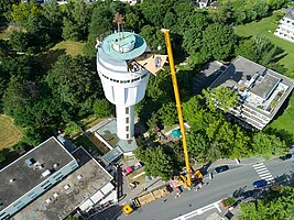 Luftaufnahme der Sanierung am Wasserturm Goldberg. Ein riesigerKran befördert Baumaterial gan nach oben.