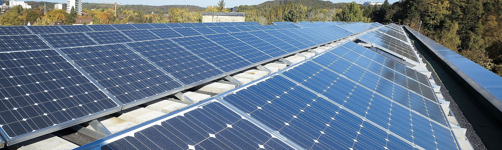 Schräg stehende Solarpanels auf einem Flachdach.