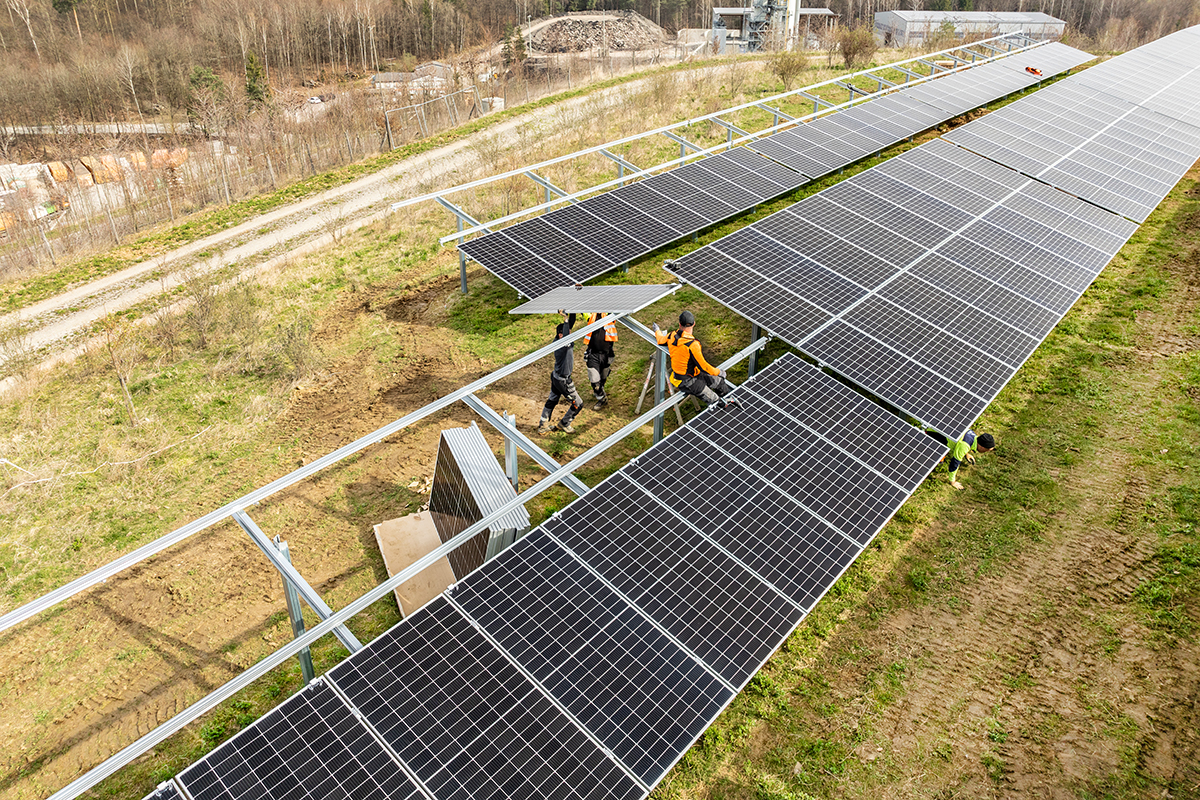 Erweiterung Fotovoltaikanlage Dachsklinge Luftaufnahme der Bauarbeiten an der Fotovoltaikanlage. Einige Arbeiter bringen die Solarpanels an die vorgesehene Konstruktion an.