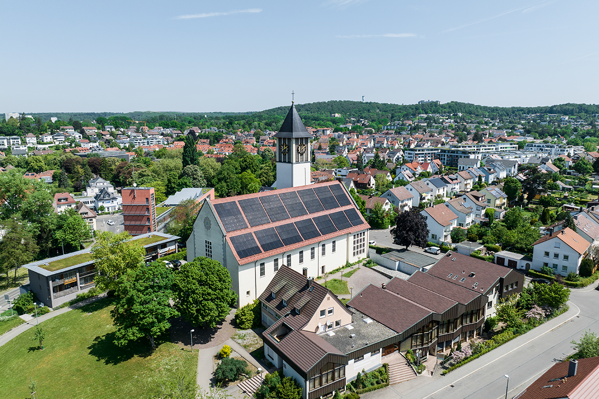 Zu sehen ist die katholische Kirche zur Heiligsten Dreifaltigkeit. Auf dem Dach ist eine PV-Anlage installiert.